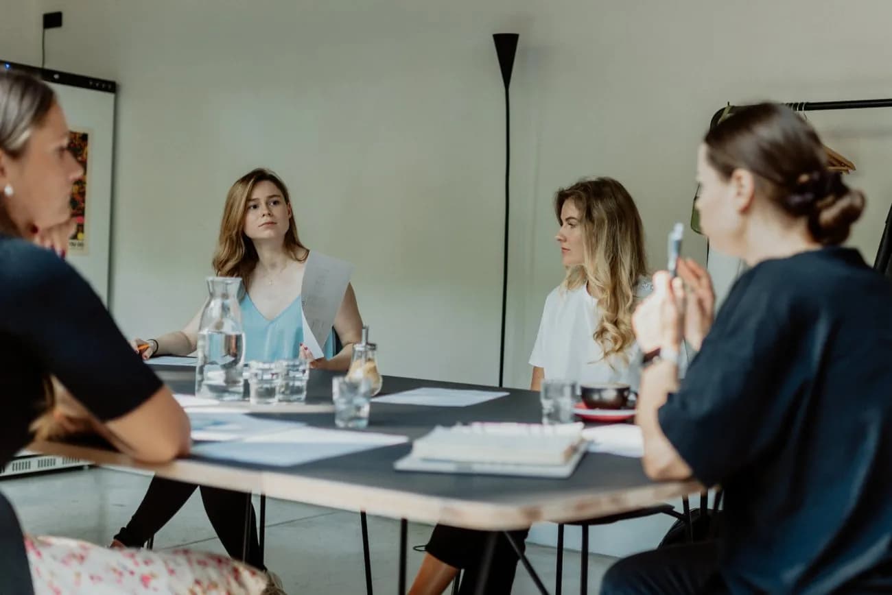 Tím lektorov na pracovnom stretnutí pri stole
